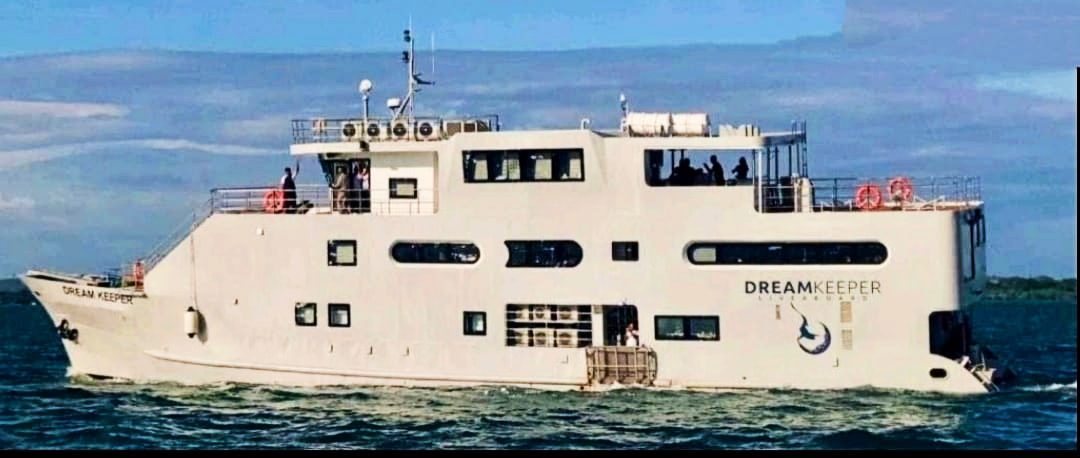 The liveaboard dive yacht M/V Dream Keeper under way, guests on her decks